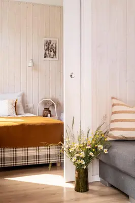 a bedroom with a bed and a vase of flowers at ZATORHOUSE in Zator
