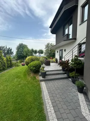 a house with a walkway in front of a yard at Noclegi u Alicji in Wola Kalinowska