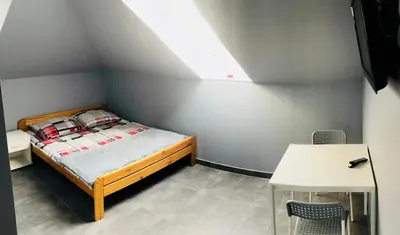 a small bedroom with a bed and a table at Noclegi u Alicji in Wola Kalinowska