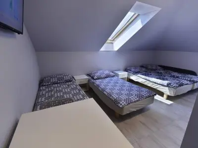 a room with three beds and a skylight at Noclegi u Alicji in Wola Kalinowska