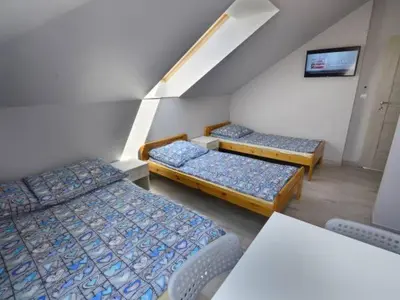 a room with three beds and a table and chairs at Noclegi u Alicji in Wola Kalinowska