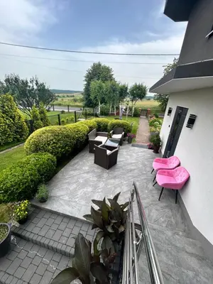 a patio with pink chairs and tables and plants at Noclegi u Alicji in Wola Kalinowska
