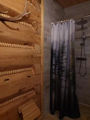a shower in a log cabin with a curtain at Domek u Heli in Limanowa