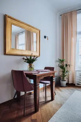 a dining room with a table and a mirror at Szpitalna 20 Apartment nr 8 in Kraków