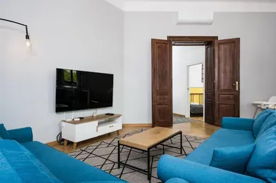 a living room with a blue couch and a tv at Beautiful apartment, great location, Old Town & Kazimierz in Kraków