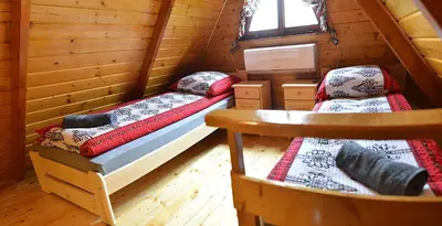 a bedroom with two beds in a log cabin at Domek drewniany Camila in Ryczów