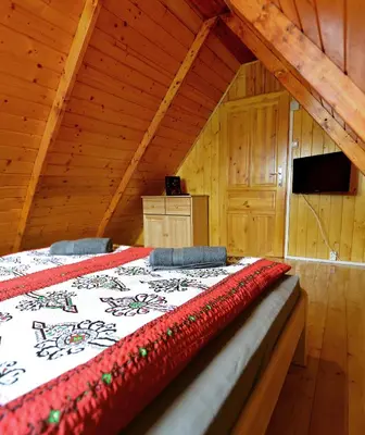 a bedroom with a bed in a wooden cabin at Domek drewniany Camila in Ryczów