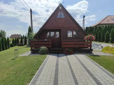 a small wooden house with a pitched roof at Domek drewniany Camila in Ryczów