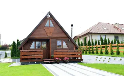 a small wooden cabin in the yard of a house at Domek drewniany Camila in Ryczów