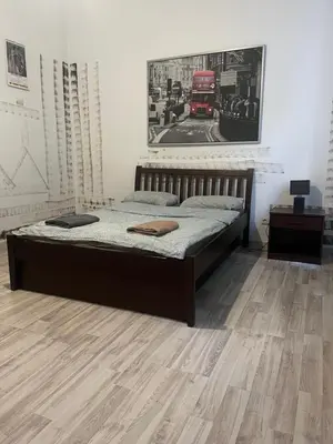 a bed in a room with a wooden floor at Coco apartment 1 in Kraków