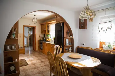 a kitchen and dining room with an archway in a room at Śmietanówka Agroturystyka in Krzczonów