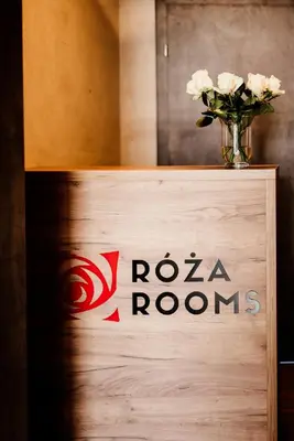 a sign for a room with a vase of flowers at Róża Rooms in Zator