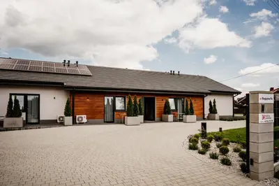 a house with a solar roof and a driveway at Róża Rooms in Zator