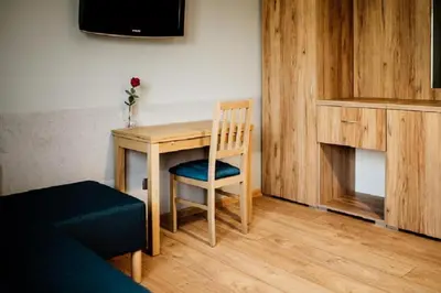 a small table with a chair and a television in a room at Róża Rooms in Zator