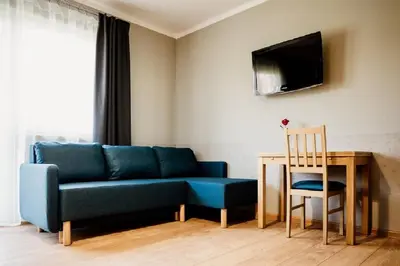 a living room with a blue couch and a table at Róża Rooms in Zator