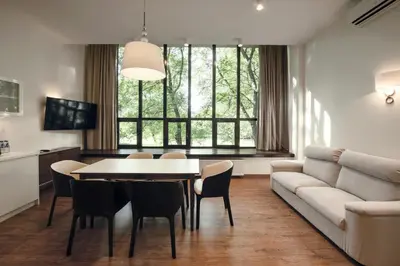 a room with two chairs and a table and a window at W Sercu Krakowa Aparthotel in Kraków