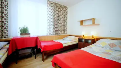 a hotel room with two beds and a table and a table and chairs at Ośrodek Wczasowy Jodła in Zawoja
