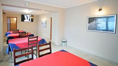 a room with four tables and chairs and a flat screen tv at Ośrodek Wczasowy Jodła in Zawoja