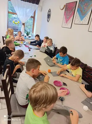 a group of children sitting at a table making crafts at Ośrodek Wczasowy Jodła in Zawoja