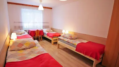 a room with three beds and a window at Ośrodek Wczasowy Jodła in Zawoja