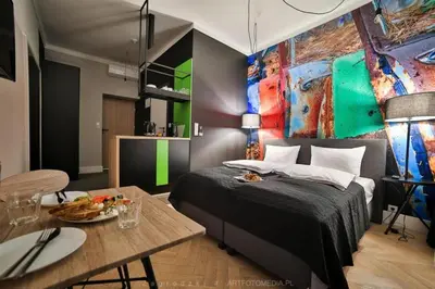 a hotel room with a bed and a table with a bottle of wine at Saint Thomas Corner - by Upstairs in Kraków