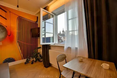a bedroom with a large bed and a table at Saint Thomas Corner - by Upstairs in Kraków