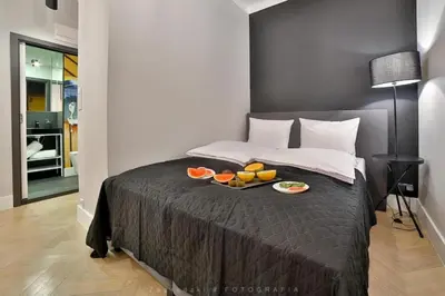 a bedroom with a large bed with towels on it at Saint Thomas Corner - by Upstairs in Kraków