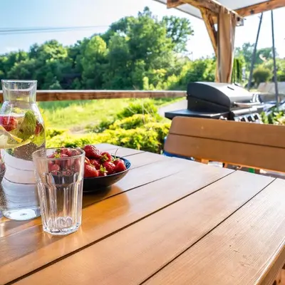 a table with a glass of wine and a bowl of fruit at Willa Sulimówka - wyjątkowy dom na wyłączność Mini SPA in Zakliczyn