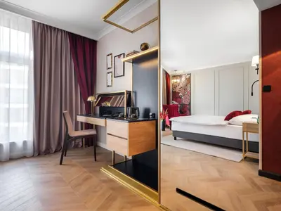 a hotel room with a bed and a desk with a computer at Hotel Golden Queen in Kraków