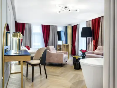 a hotel room with a bath tub and a suite at Hotel Golden Queen in Kraków