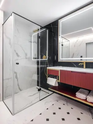 a bathroom with a glass shower and a sink at Hotel Golden Queen in Kraków