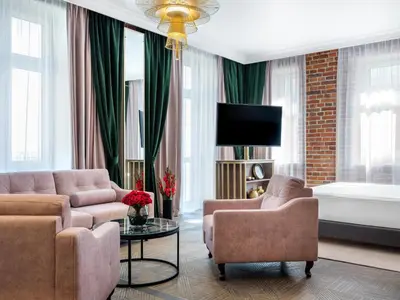 a living room with a couch and a bed at Hotel Golden Queen in Kraków