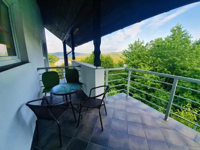 a balcony with chairs and a table and a railing at Dom nad Jeziorem Rożnowskim in Tęgoborze