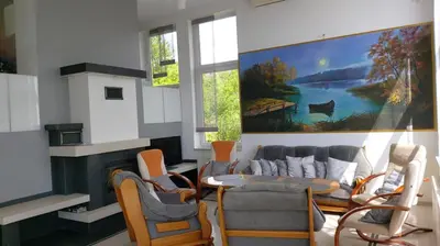 a living room with a couch and a table and chairs at Dom nad Jeziorem Rożnowskim in Tęgoborze