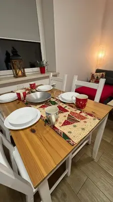 a wooden table with white plates on top of it at Apartamenty ZATOR20 2 min od Energylandii in Zator