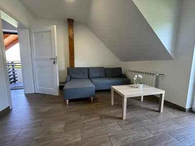 a living room with a blue couch and a table at Apartamenty ZATOR20 2 min od Energylandii in Zator