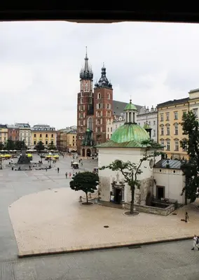 a city square with a building with a green dome at Main Square 18 view 2 in Kraków