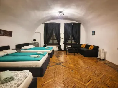 a room with three beds and a couch at Main Square 18 view 2 in Kraków
