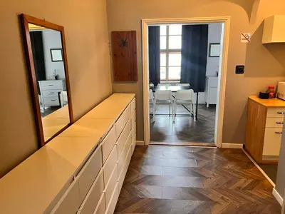 a bathroom with a dresser and a mirror and a dining room at Main Square 18 view 2 in Kraków