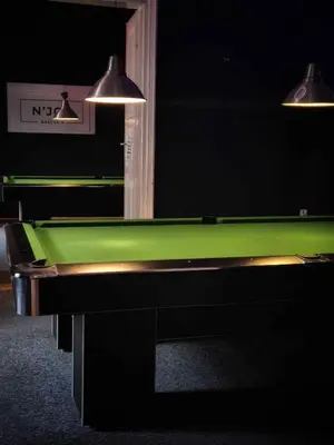 a green pool table in a room with two lights at Main Square 18 view 2 in Kraków