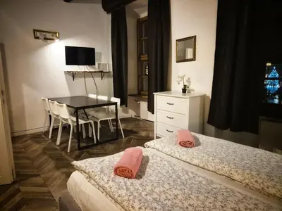 a bedroom with two beds and a table and a table and chairs at Main Square 18 view 2 in Kraków