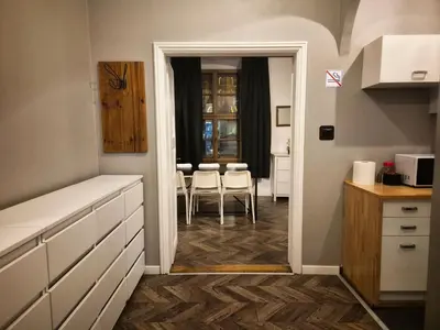 a kitchen with white cabinets and a table and chairs at Main Square 18 view 2 in Kraków