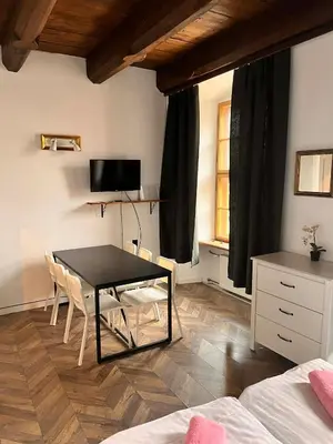 a room with a table and chairs and a television at Main Square 18 view 2 in Kraków