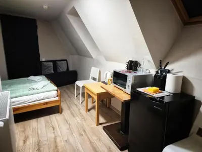 a small room with a small table and a microwave at Bracka 4 Apartament in Kraków