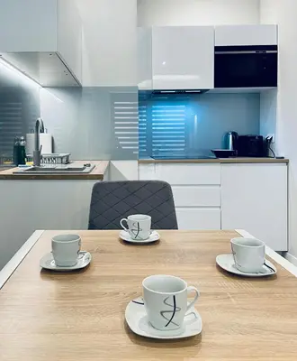 a wooden table with two coffee cups on top of it at Modern Silver Apartment in Kraków