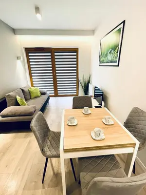 a living room with a table and chairs and a couch at Modern Silver Apartment in Kraków