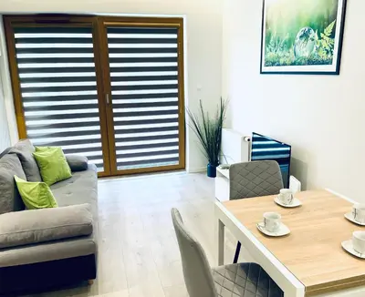 a living room with a couch and a table at Modern Silver Apartment in Kraków