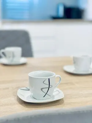 a coffee cup on a plate on a table at Modern Silver Apartment in Kraków