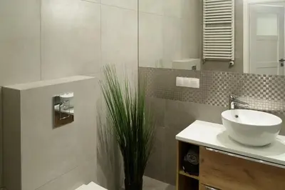 a bathroom with a sink and a plant at Modern Silver Apartment in Kraków