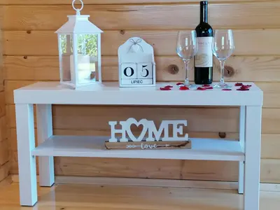 a white table with wine glasses and a bottle of wine at Nocleg Zator Domki Paradise Pod Palmami in Zator